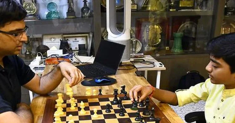 Un jugador joven y un gran maestro estudian juntos una posición en el tablero