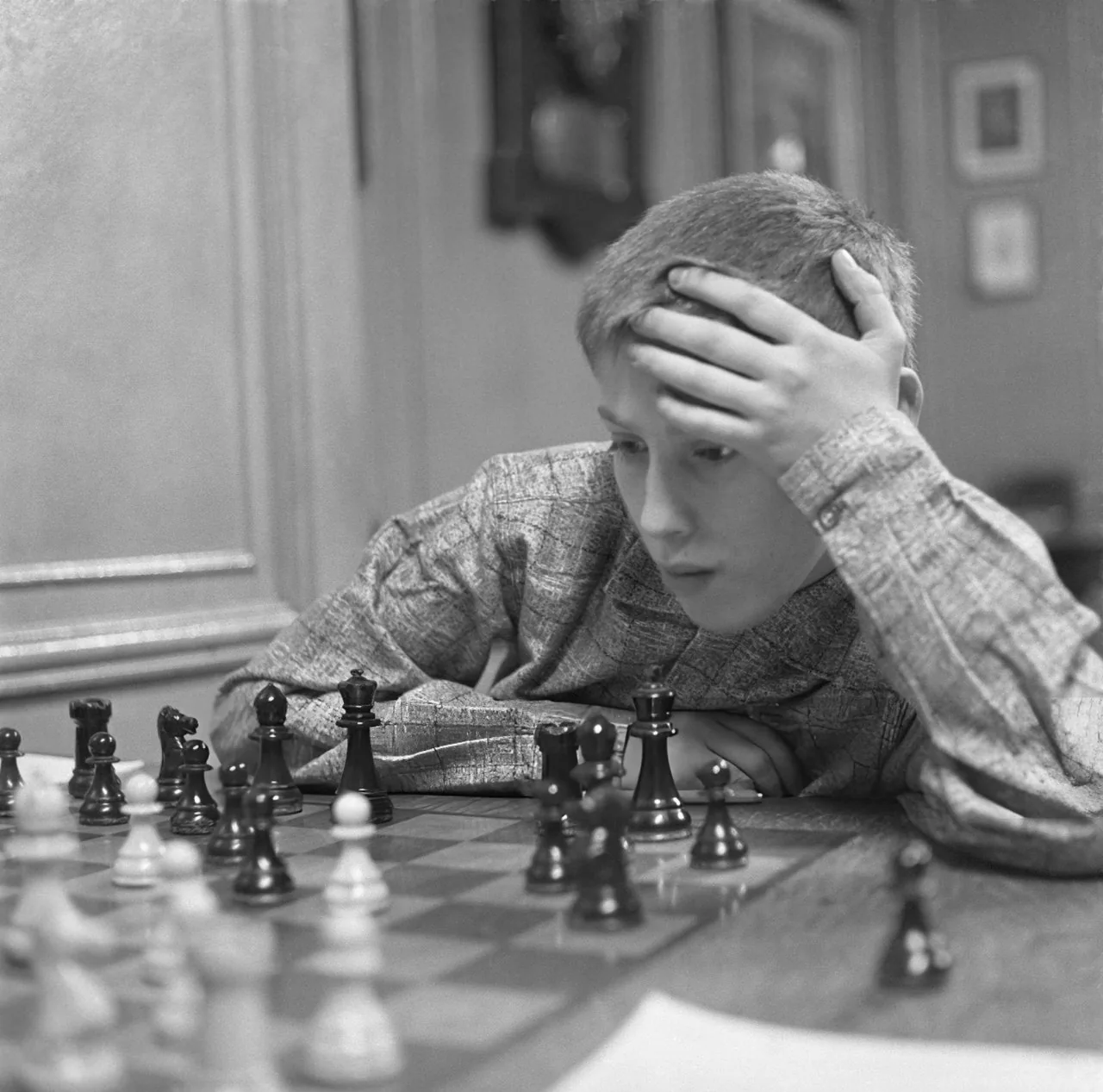 Thirteen-year-old Bobby Fischer studying the board